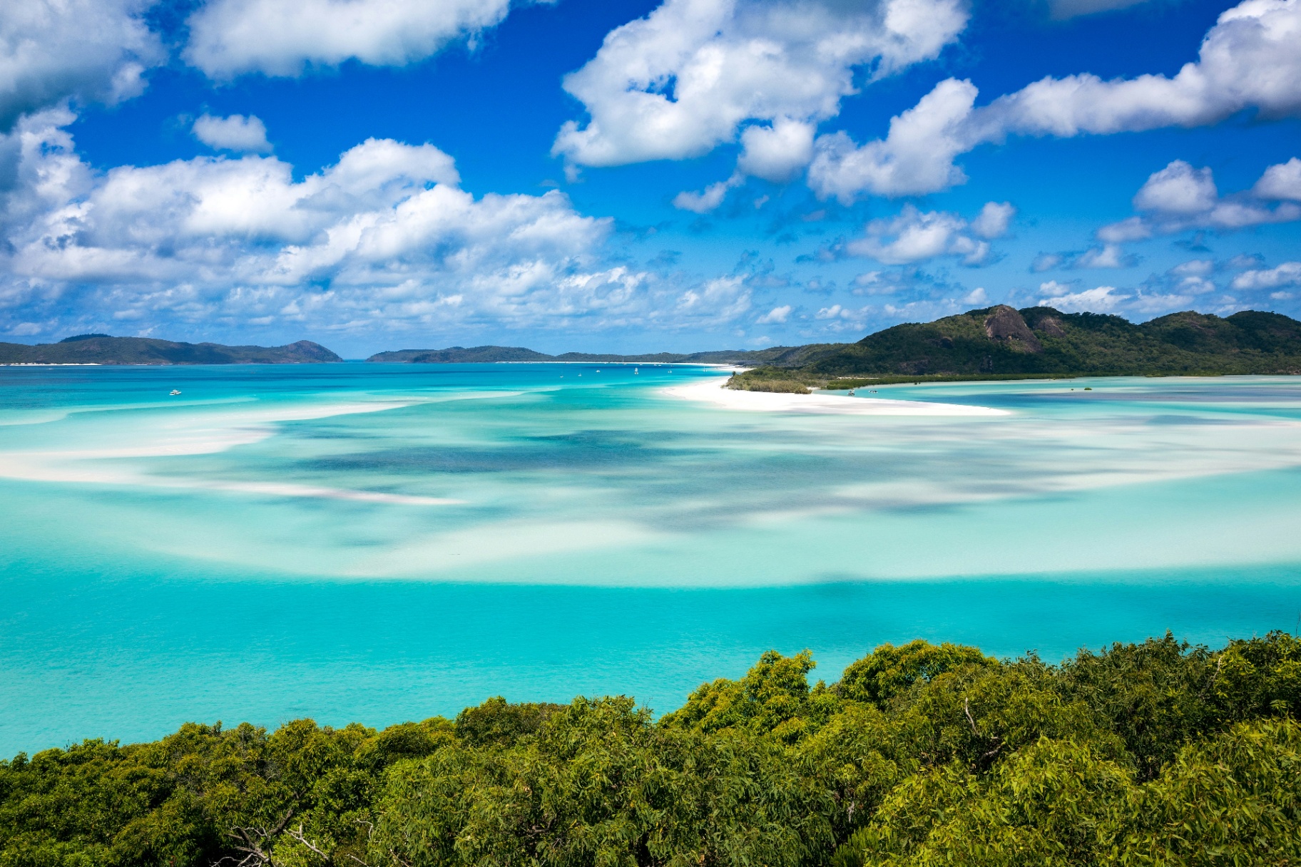 A turquoise Whitsundays lagoon meeting a white sand spit.