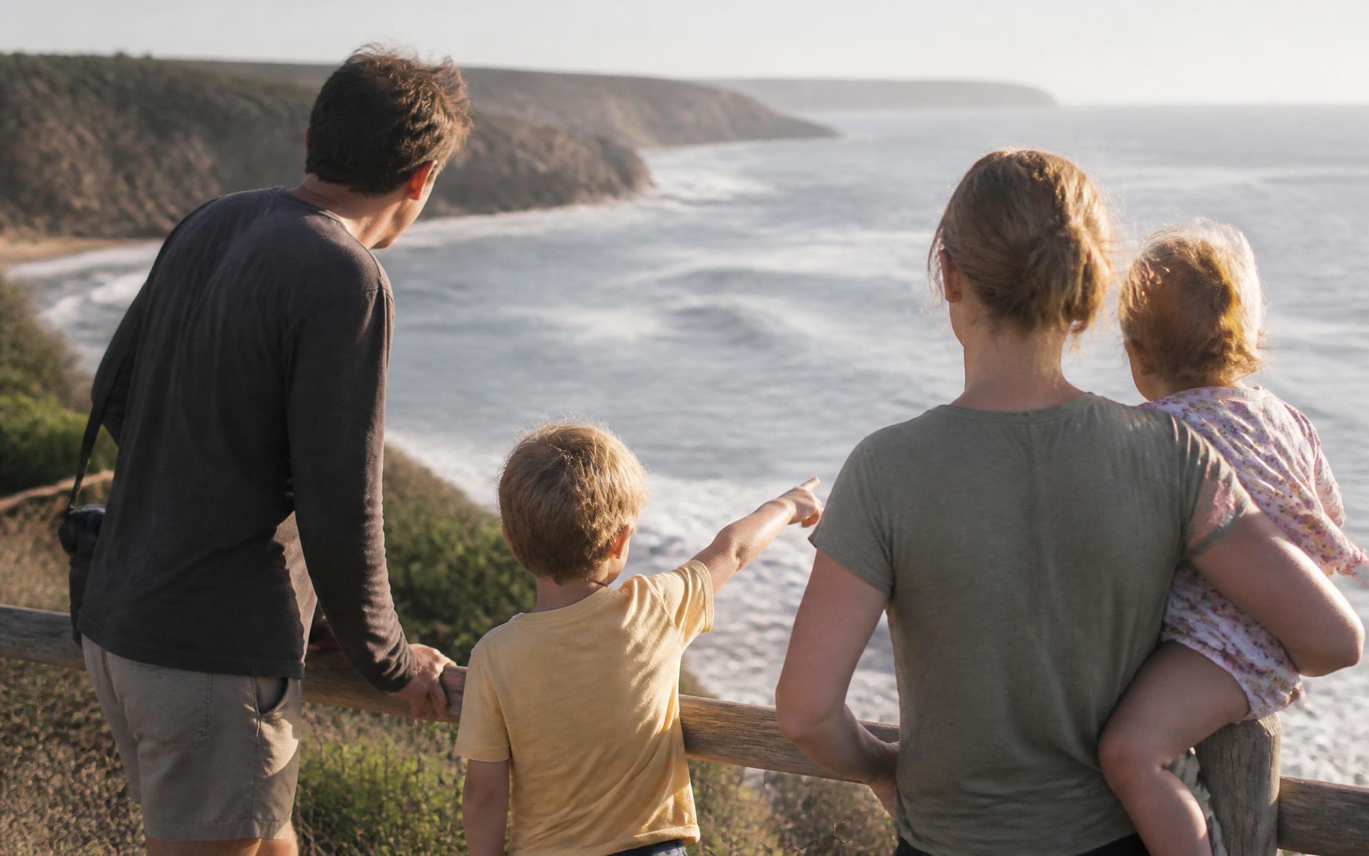 Travellers pausing at a quiet coastal lookout in warm afternoon light