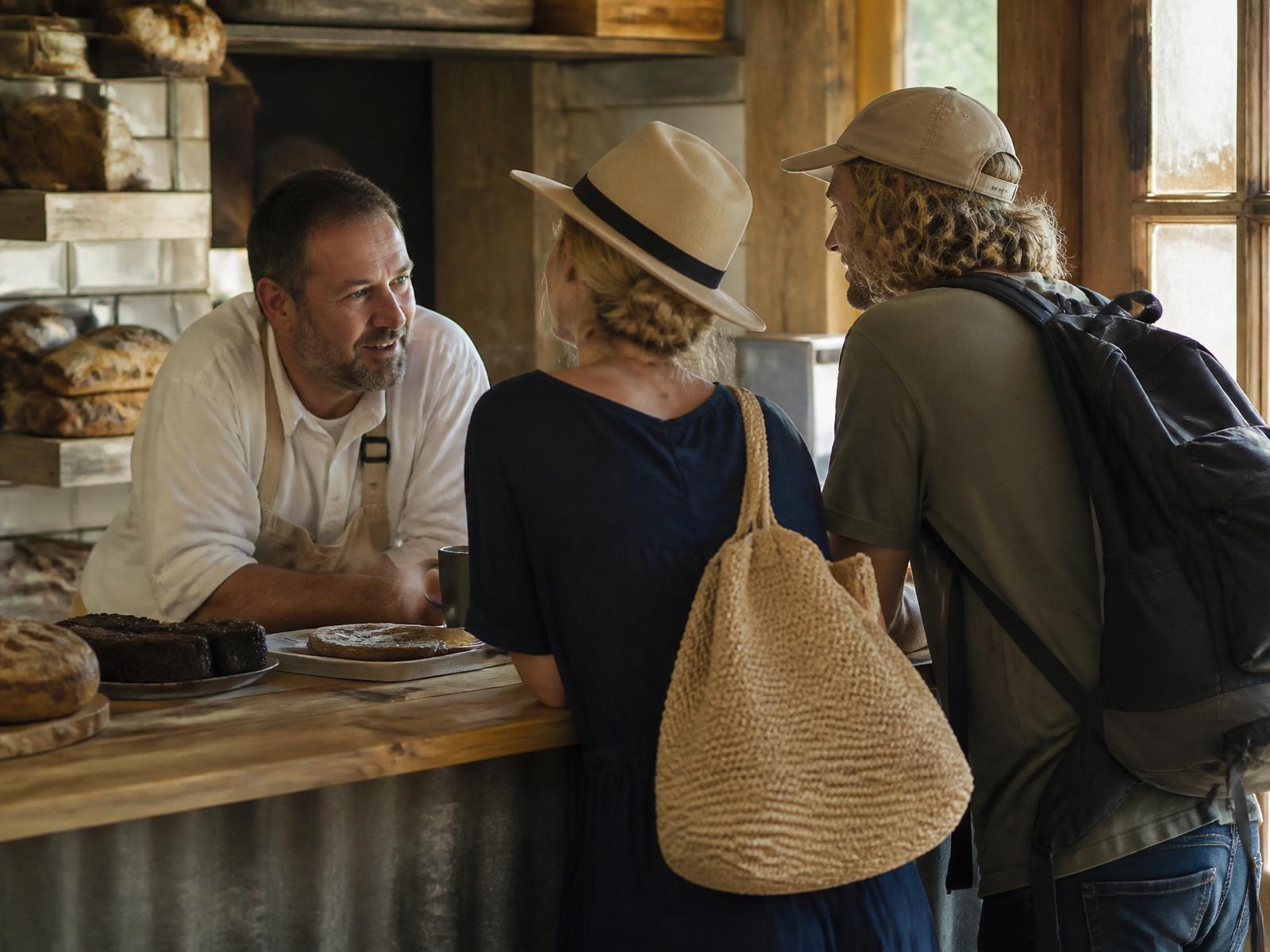 A traveller at an outdoor cafe asking a question on their phone.